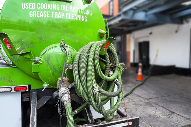 a grease trap being pumped by a sanitation technician in Bagdad